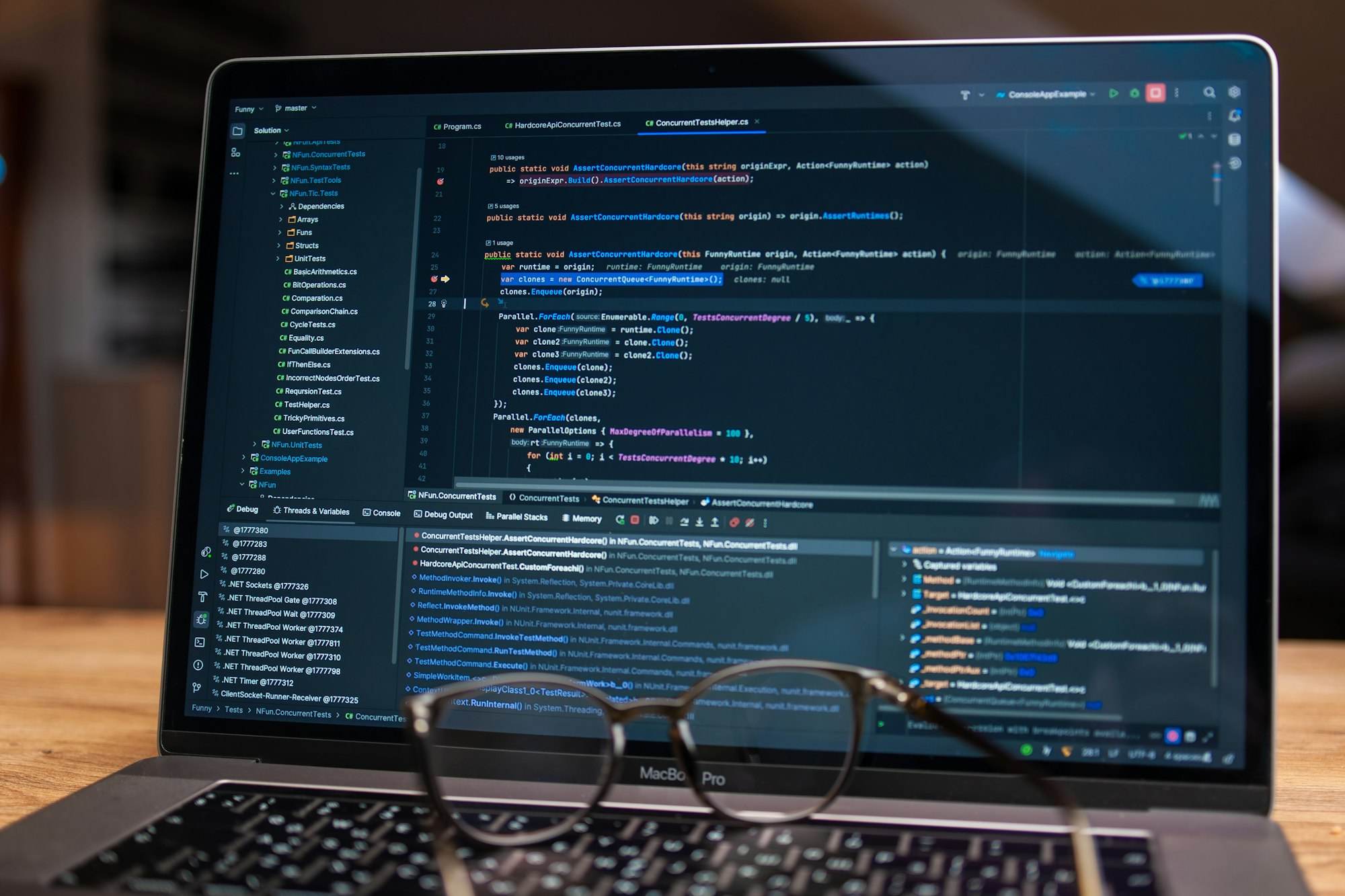 Laptop mit geöffnetem Quelltext, davor liegt eine Brille