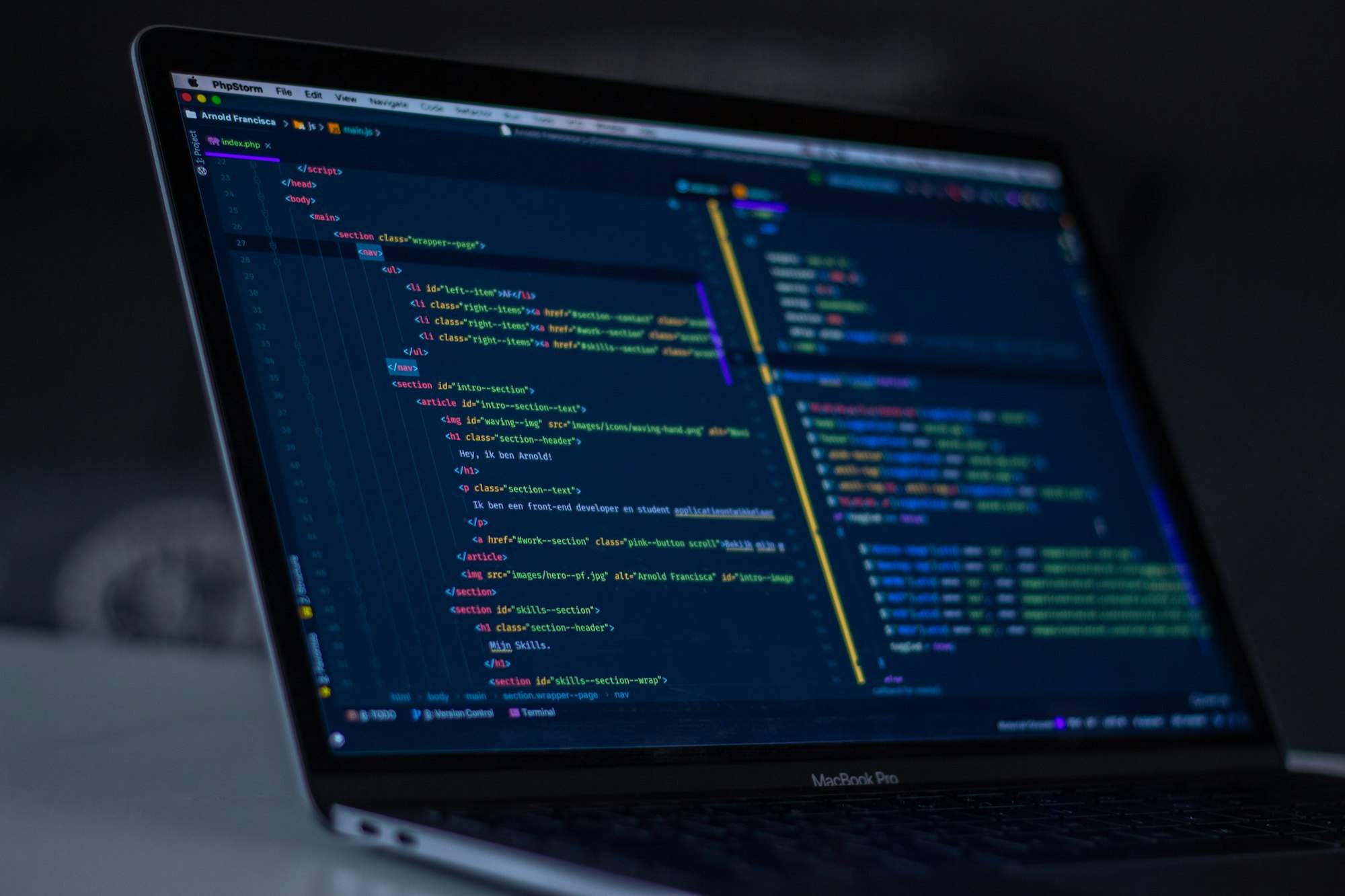 Aufgeklappter Laptop mit Programmcode in einem dunklen Editor